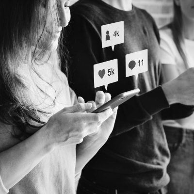 Friends using smartphones together outdoors